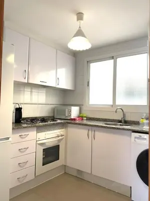a white kitchen with white cabinets and a sink at UIM Mediterraneo Diagonal 17 Wifi in Puerto de Sagunto