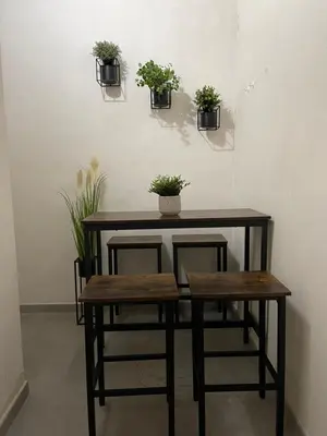 a table and stool with potted plants on the wall at UIM Mediterraneo PB Aragon A Wifi in Puerto de Sagunto