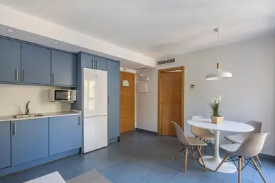 a kitchen with blue cabinets and a table with chairs at Stancia Carmen in Valencia