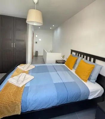 a large blue bed with yellow pillows in a room at UIM Mediterraneo Casita Palancia Wifi in Puerto de Sagunto