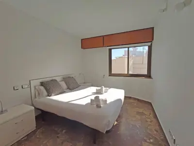 a bedroom with a large white bed and a window at Sunny apartment with fantastic terrace views! in Valencia