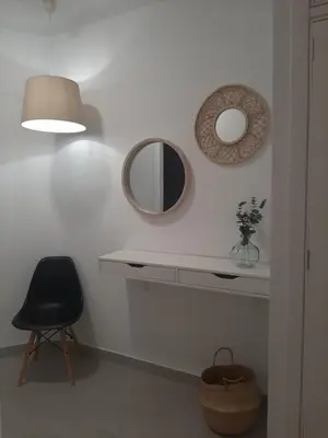 a room with a table and a mirror and a chair at Sol Playa Suites in Valencia