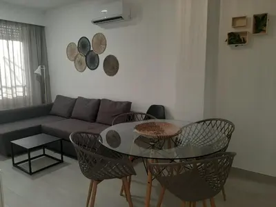 a living room with a couch and a table and chairs at Sol Playa Suites in Valencia