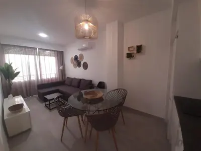 a living room with a couch and a table and chairs at Sol Playa Suites in Valencia