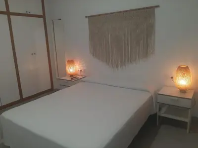 a bedroom with a large white bed and two lamps at Sol Playa Suites in Valencia