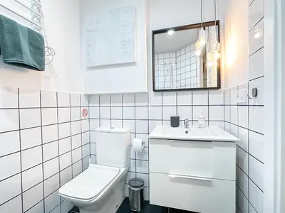 a white bathroom with a toilet and a sink at Budget Inn in Valencia