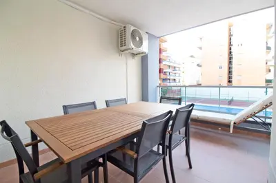 a dining room with a table and chairs and a window at Global Vacacional, Apartamento en la playa de Canet d'en Berenguer in Canet de Berenguer