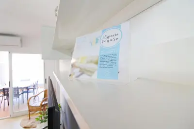 a sign on a wall in a room with a table at Global Vacacional, Apartamento en la playa de Canet d'en Berenguer in Canet de Berenguer
