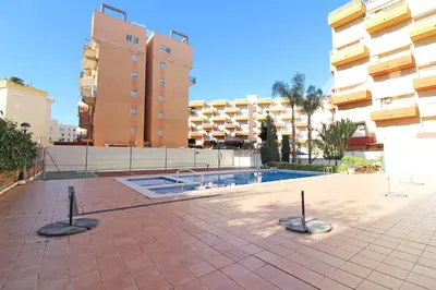 a swimming pool in the middle of a courtyard with buildings at Global Vacacional, Apartamento en la playa de Canet d'en Berenguer in Canet de Berenguer