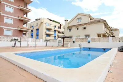 a swimming pool in front of some buildings at Global Vacacional, Estudio para parejas con piscina en Canet playa in Canet de Berenguer