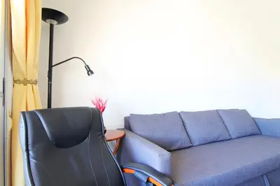 a living room with a blue couch and a chair at Global Vacacional, Estudio para parejas con piscina en Canet playa in Canet de Berenguer