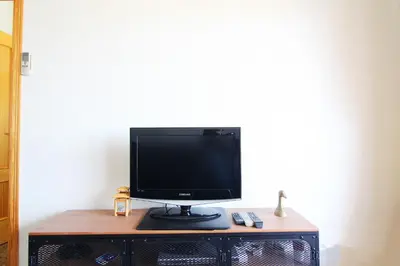 a computer monitor sitting on top of a desk at Global Vacacional, Estudio para parejas con piscina en Canet playa in Canet de Berenguer