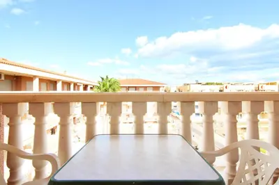 a table and chairs on a balcony with a view at Global Vacacional, Estudio para parejas con piscina en Canet playa in Canet de Berenguer