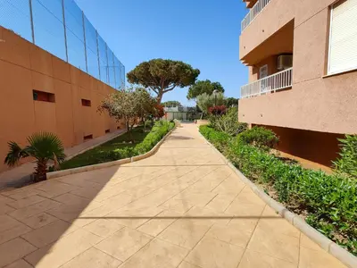 a park with benches and trees in front of a building at Global Vacacional, Apartamento con buenas vistas en Canet playa in Canet de Berenguer