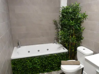 a bathroom with a white bath tub next to a toilet at Intimo y Acogedor 