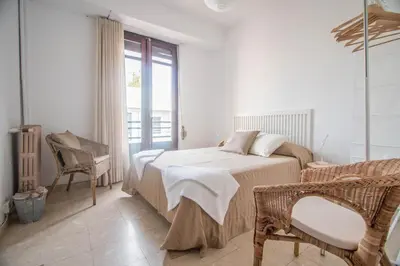 a bedroom with a bed and a chair and a window at Rotaret in Valencia