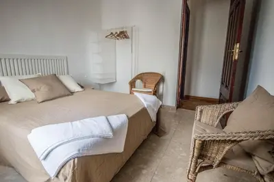 a bedroom with a large bed and a chair at Rotaret in Valencia