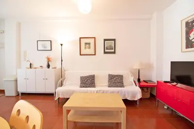 a living room with a white couch and a table at Global Vacacional, Apartamento con piscina en playa Corinto in Sagunto
