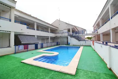 an empty swimming pool in the middle of a building at Global Vacacional, Apartamento con piscina en playa Corinto in Sagunto
