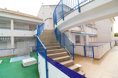a staircase in a building with blue railings at Global Vacacional, Apartamento con piscina en playa Corinto in Sagunto
