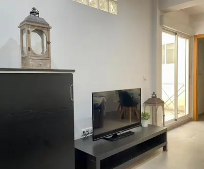 a living room with a flat screen tv on a table at UIM Mediterraneo PB Aragon B Wifi in Puerto de Sagunto