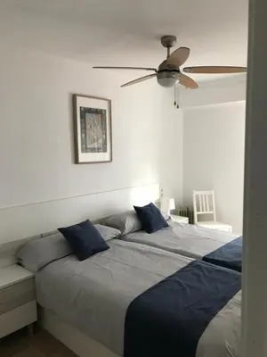 a bedroom with two beds and a ceiling fan at 150m2 Con vistas al Mar y al Castillo de Cullera in Cullera