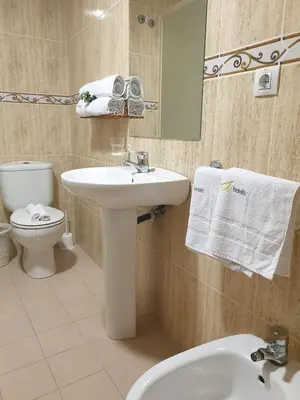 a bathroom with a sink and a toilet and a mirror at Hotel M5 Valencia Aeropuerto in Manises