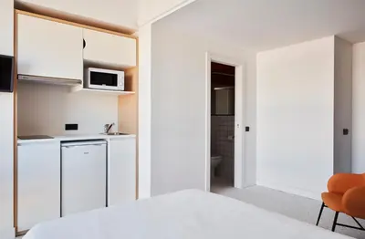 a room with a white kitchen with a microwave at Resa Patacona in Valencia