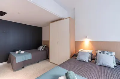 a bedroom with two beds and a cabinet at Resa Patacona in Valencia
