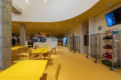 a cafeteria with yellow tables and chairs in a building at Resa Patacona in Valencia