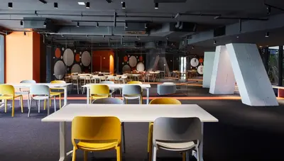 a group of tables and yellow chairs in a room at Resa Patacona in Valencia