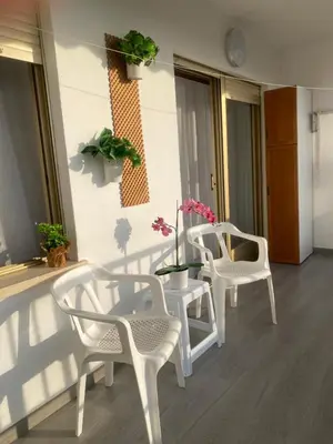 a room with two white chairs and a table and some plants at 1a línea con PISCINA Nuevo in Cullera