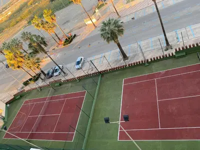 an overhead view of a tennis court and a street at 1a línea con PISCINA Nuevo in Cullera
