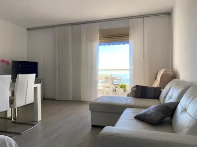 a living room with a couch and a table at 1a línea con PISCINA Nuevo in Cullera