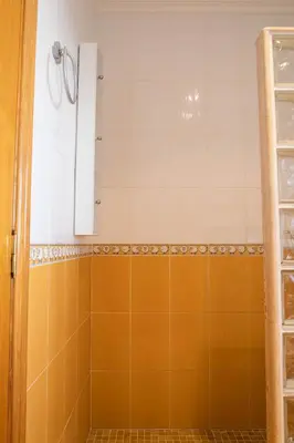 a bathroom with an orange and white tiled shower at FLORIT FLATS - The Orange Lemon Tree House in La Eliana