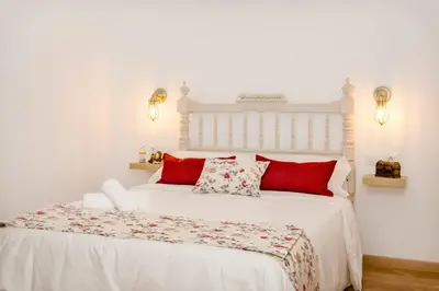 a bedroom with a white bed with red pillows at PALACIO Boutique in Anna