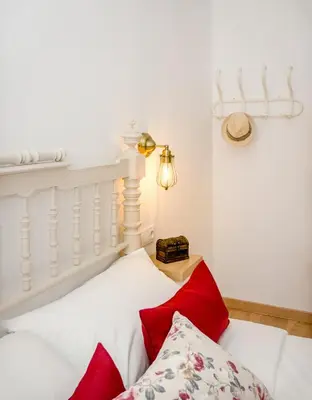 a white bed with red pillows in a room at PALACIO Boutique in Anna