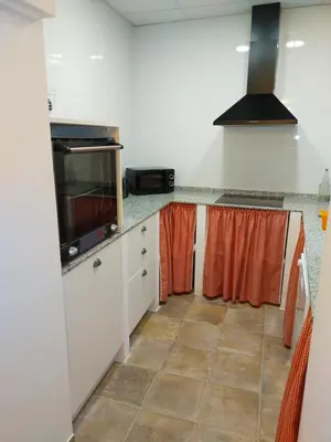a kitchen with white cabinets and orange curtains at PALACIO Boutique in Anna