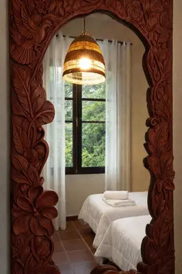 a mirror in a room with two beds and a window at Masía de San Juan Casas número 3 y 5, con piscina, aire acondicionado y vistas a la montaña in Segorbe