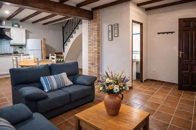 a living room with a blue couch and a table at Masía de San Juan Casas número 3 y 5, con piscina, aire acondicionado y vistas a la montaña in Segorbe