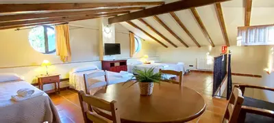 a room with a dining table and a living room at Masía de San Juan Casas número 3 y 5, con piscina, aire acondicionado y vistas a la montaña in Segorbe