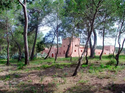 a group of trees in front of a brick building at Masía de San Juan Casas número 3 y 5, con piscina, aire acondicionado y vistas a la montaña in Segorbe