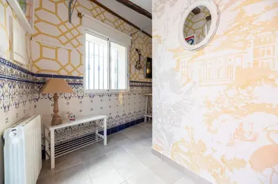 a bathroom with yellow and blue wallpaper and a radiator at Boutique House Alzira in Alzira