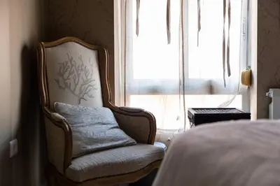 a chair in a bedroom next to a window at Boutique House Alzira in Alzira