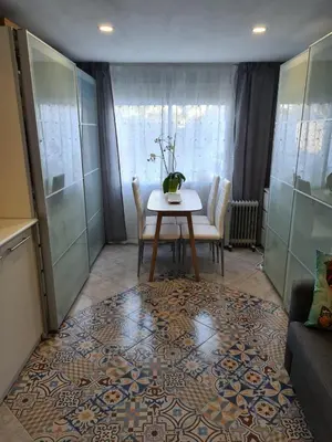 a living room with a table and chairs on a rug at Casa Coqueta in Almarda