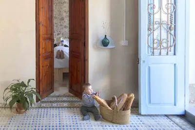 a baby sitting in a room with a basket at Villa Serrano, La casa rural de los mil suelos in Valencia