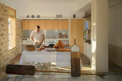 a man standing in a kitchen preparing food at Villa Serrano, La casa rural de los mil suelos in Valencia