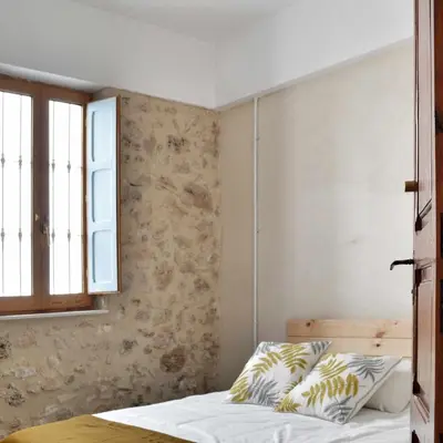 a bedroom with a bed and a window at Villa Serrano, La casa rural de los mil suelos in Valencia