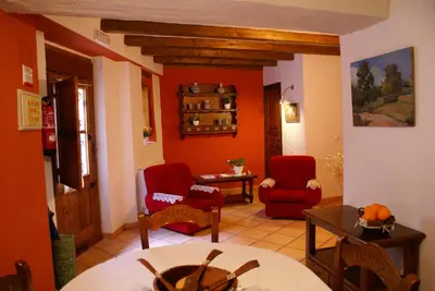 a living room with red chairs and a table at Casa de Pueblo El Patio de las Cebollas in Segorbe