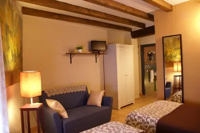 a living room with a blue couch and a tv at Casa de Pueblo El Patio de las Cebollas in Segorbe